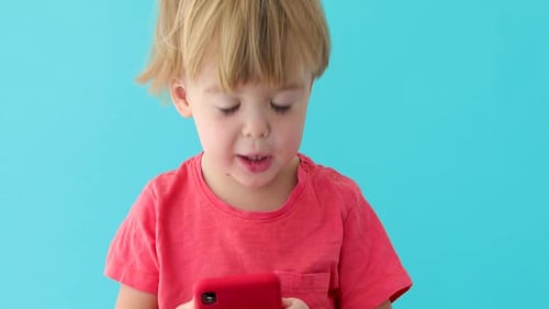 Blond Haired Child Holding a Cellphone