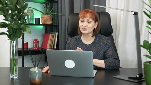 Woman is doing online video chat conference sitting at office