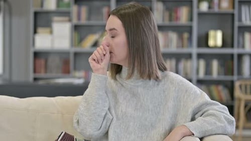 Young Woman Coughing at Home on Couch