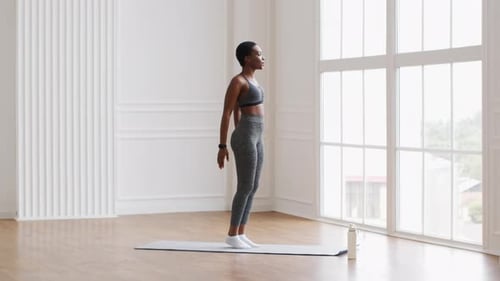 Sporty African American Female Doing Jump Squats Exercise While Training At Home