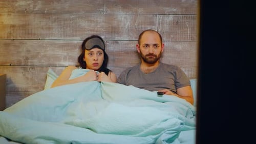 Couple Watching Television in Bed at Night