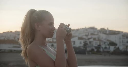 Young Woman Photographing With Vintage Camera By Sea