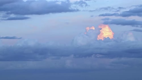Magical Blue and Orange Clouds Swirl Over the Mountain at Sunset