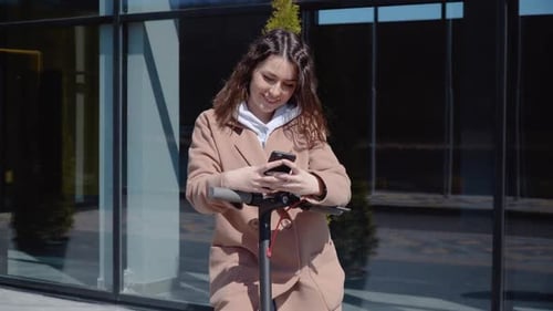 Young Adult Using Phone with Scooter