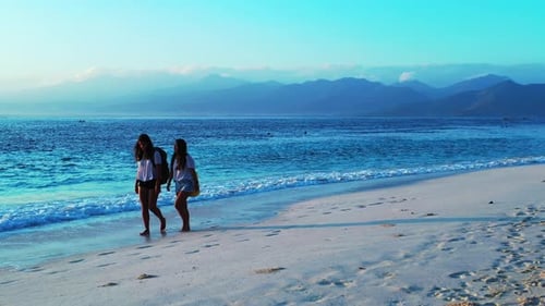 Pretty happy ladies on holiday enjoying life at the beach on summer white sandy and blue background