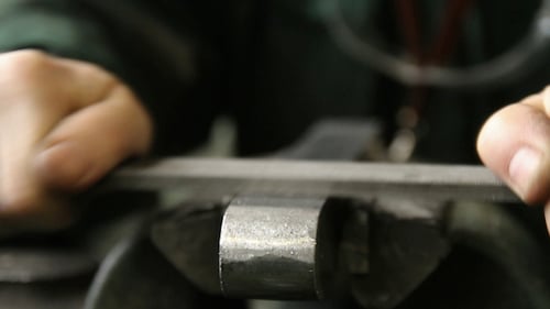 Hands Filing Metal in the Workshop