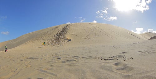 People Enjoying Sand Dunes in Desert Landscape