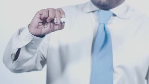 Writing EBITDA on Clear Surface Close Up