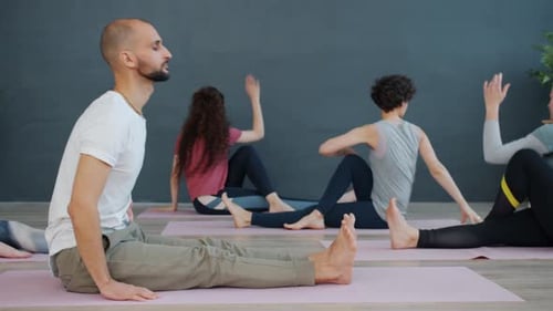 Adults Practicing Yoga Poses Together in Studio