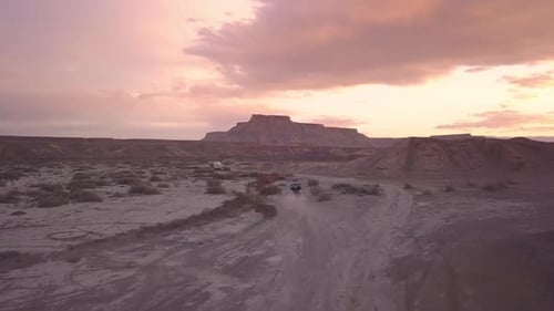 Aerial view following OHV driving through the desert