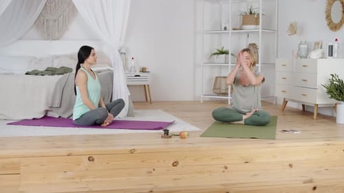 Yogalehrer zeigt einer jungen Frau Atemübungen