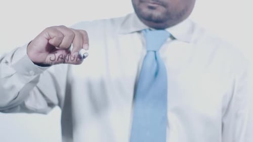 Man Writing January on Clear Surface with Marker
