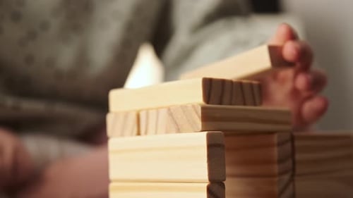 El
niño pequeño juega un juego de mesa, el niño construye con bloques de ladrillos de madera.