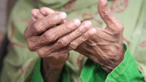 Senior Hands Massaging Fingers in Close Up