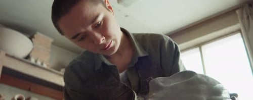 Young Adult Shaping Clay in Bright Studio