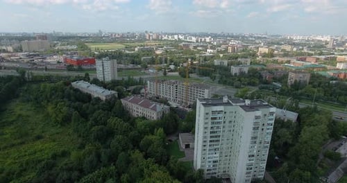 An Aerial View of a Sunny Urbanscape Among Green Trees