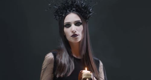 Woman with Skull Candle in Dark Setting