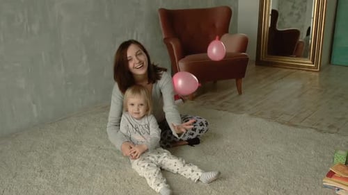 Mother and Child Celebrate with Balloons Indoors