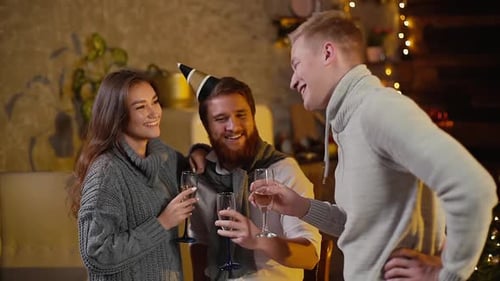 Jovem tilintando taças de champanhe com casal em comemoração festa de ano novo