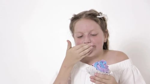 Happy Girl Eating Cupcake with Colorful Frosting