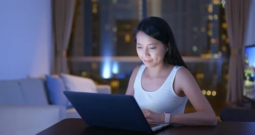 Woman Working on Laptop at Night Indoors