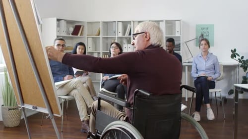 Presenter in Wheelchair Leading Group Discussion in Office