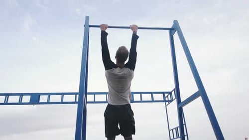 Young Man Doing Parkour Tricks on the Beach Near the Sea