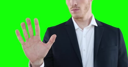 Mid section of a Caucasian man raising hand on green background