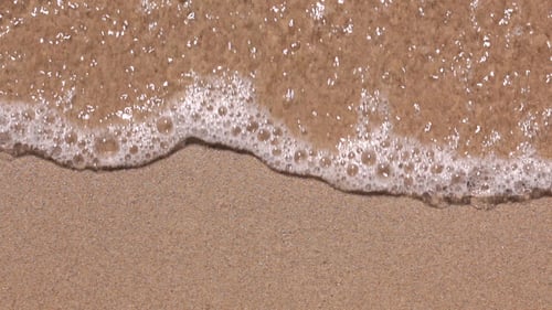 Gentle Ocean Waves Washing Over Sandy Beach