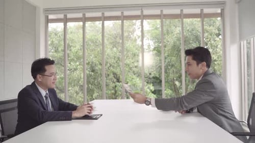 Men Exchanging Money in a Bright Office
