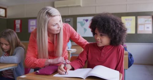 Female teacher talking to a boy in the class at school