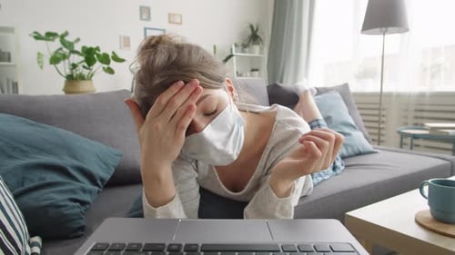 Woman in Medical Face Mask Chatting on Web Call from Home