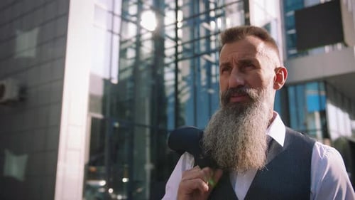 Portrait of Handsome Bearded Mature Man in Suit Outdoors on Modern Building Background During Sunny