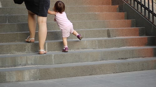 Child and Adult Walking up City Stairs
