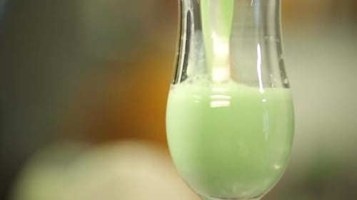 Refreshing Green Cocktail Preparation in Elegant Glass