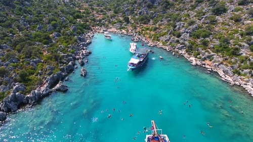 Diving Tour Boats Anchored in a Small Bay in Turkey and Tourists Vacationers Swimming in the Sea