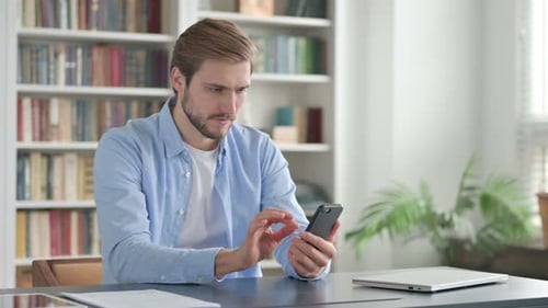 Frustrated Man Reacting to News on Phone