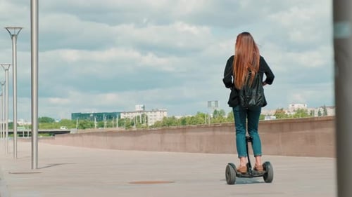 Frau reitet Gyroscooter an sonnigem Tag
