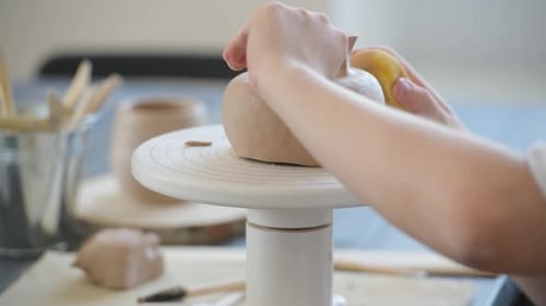 Close-up of Potter Making Pot in Pottery Workshop. Using Sponge and Water for Moisturizing Clay.