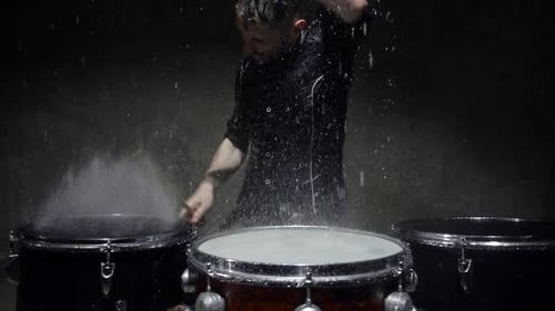 Drummer Plays Drums Energetically in the Rain