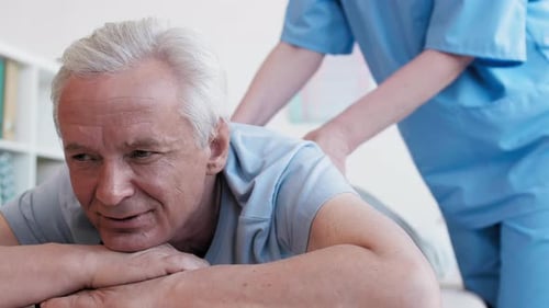 Elderly Man Receives Caregiver Massage in Bed