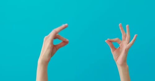 Hands Pinching Together Against Blue Background