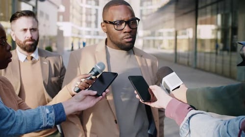 Black Man Giving Interview to TV Correspondents on Street