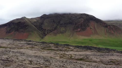 Aerial of Mountain Covered with Grass at the Bottom and with Mudflows in Front
