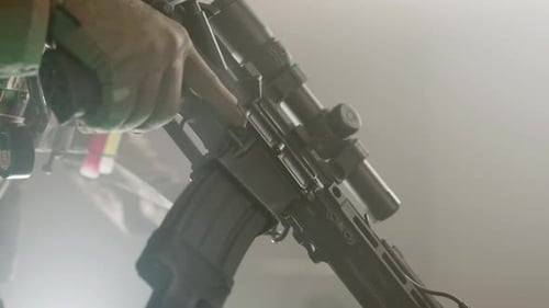 Unerkennbarer Mann lädt Gewehr im dunklen Raum