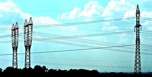 Silhouetted Electrical Towers and Power Lines Against Blue Sky