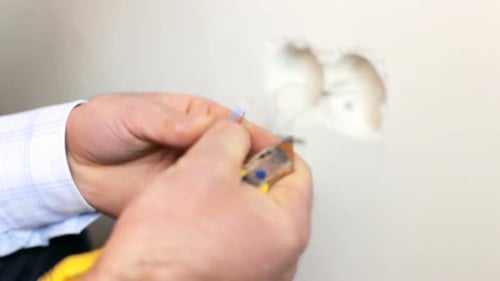 Man Prepares Electrical Wire for Repair Task