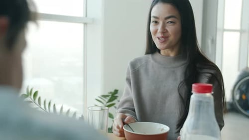 Woman Eating Breakfast and Talking to Friend