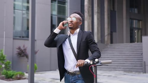 Man Talking on Phone with Electric Scooter in City
