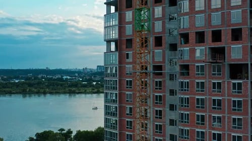 Vuelo aéreo horizontal a lo largo de la construcción de un edificio de varios pisos